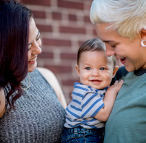 Two parents holding an infant