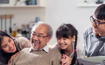 A happy multigenerational family sitting on the couch.
