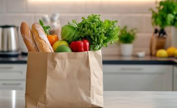 Bag of food from the grocery store on an island in a kitchen. 