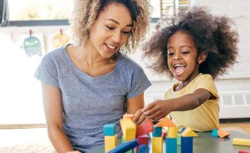 Mother and daughter playing with colorful wooden blocks