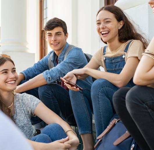 A group of teenagers sitting together outside.