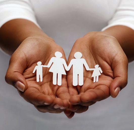 Hands holding paper cut-out family