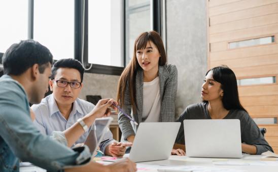 A group of colleagues gathered around a table brainstorming. 