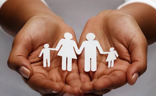 Hands holding paper cut-out family