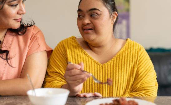 Two people eating at a table. 