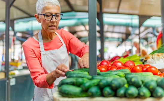 Women tending to her vegetables at a farmers' market