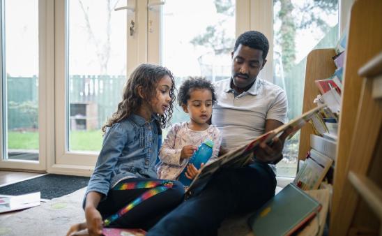 Dad reads to two young daughters
