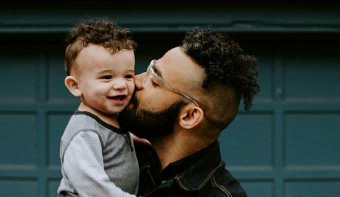 Man holding his son and giving him a kiss