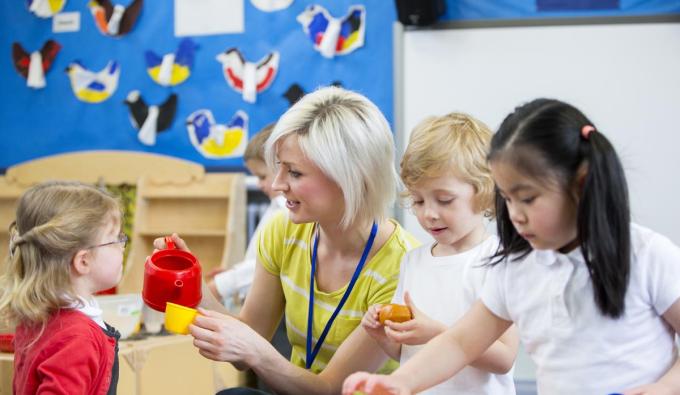 Teacher in a daycare setting playing with three children