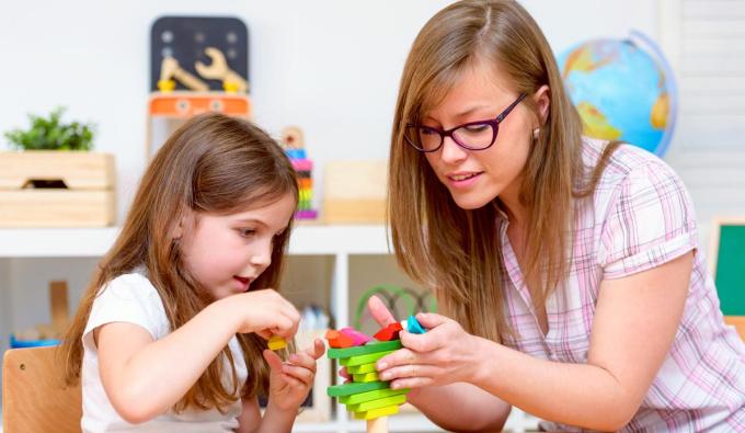 Early childhood educator working with a child in a classroom-type setting