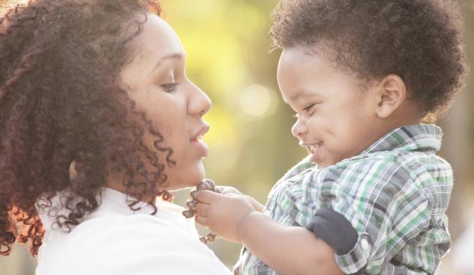 Woman holding her child as he smiles at her