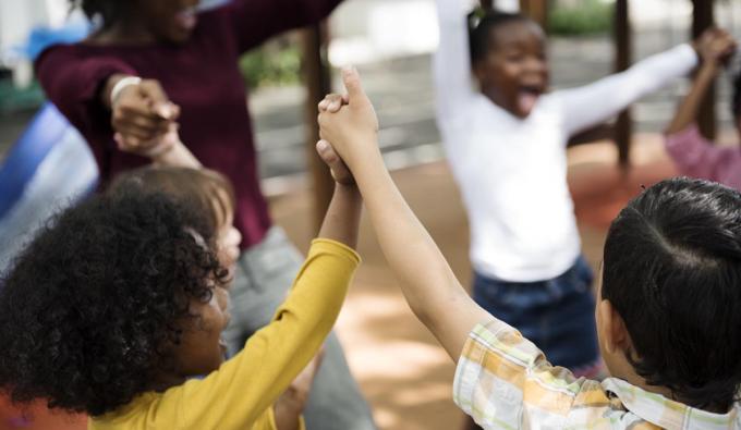 Children in a circle holding hands and playing