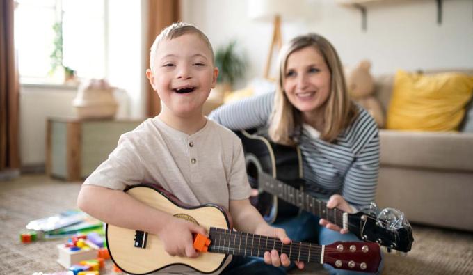 Early educator playing guitar with child
