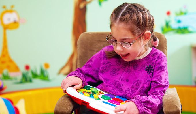 Child sitting in a chair playing with a toy