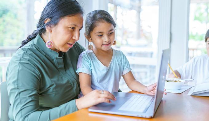 Mom and daughter looking at a laptop