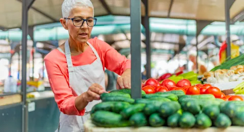Women tending to her vegetables at a farmers' market