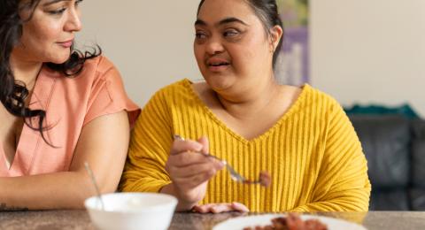 Two people eating at a table. 