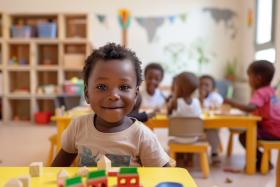 Boy smiles playing with trains