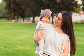 Mom looks at her baby wearing a knitted hat