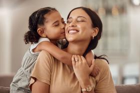 Daughter hugs her mom and kisses her cheek