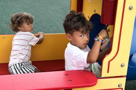 Boy plays on a train structure at the park