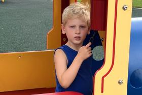 Child rings the bell on the train at the playground