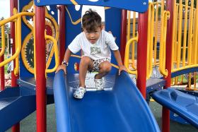 Child gets into a seated position at the top of the slide