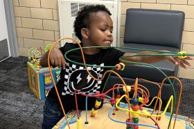 Boy plays with a bead maze