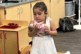 Girl cradles a baby doll