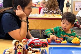 Toddler playing with toy fruits and veggies