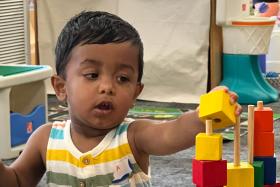 Toddler stacks colorful blocks
