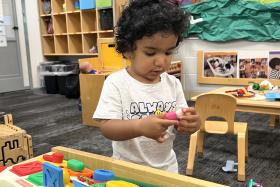 Toddler playing with a small toy