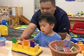 Dad and toddler play with a pop-up toy