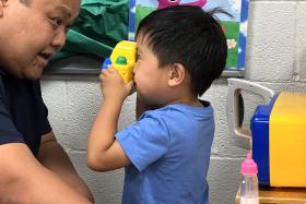 Toddler takes a picture of his dad using a toy camera