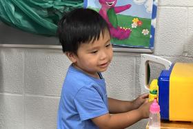 Toddler plays in a toy kitchen