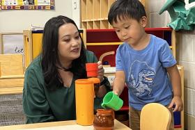 Toddler and mom play with a toy coffee set