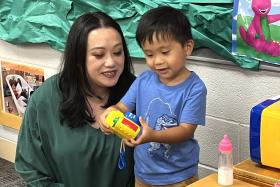 Toddler shows mom a toy camera