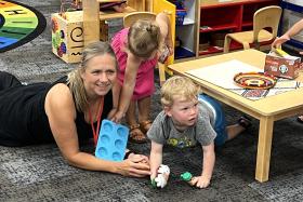 ECFE teacher playing with kids on the floor