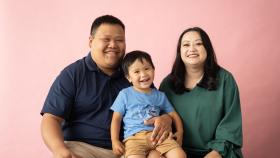 A Hmong mom and dad pose with their son