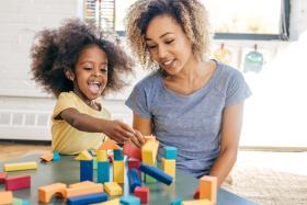 Mom and toddler play with colorful wooden blocks